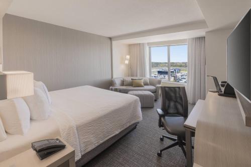 a hotel room with a bed and a desk at Courtyard by Marriott Halifax Dartmouth in Halifax