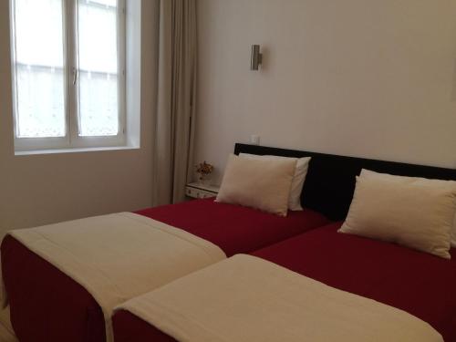 1 cama con 2 almohadas junto a una ventana en Clerigos-H, en Oporto