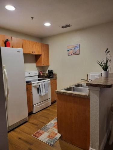 a kitchen with a white refrigerator and a sink at Blue Hideaway With Shared Spaces in Riviera Beach