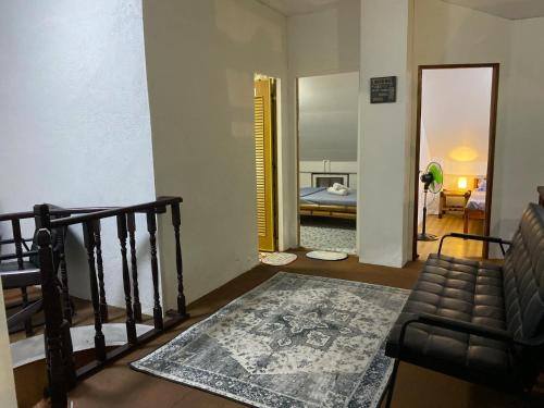 a living room with a staircase and a bedroom at Koa's Beach House in Tangalan