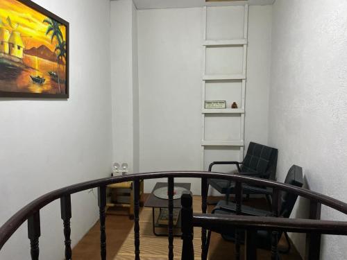 a staircase with a chair and a painting on the wall at Koa's Beach House in Tangalan
