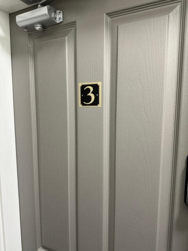 a elevator door with the number three on it at Comfort Suite in Manchester in Stalybridge
