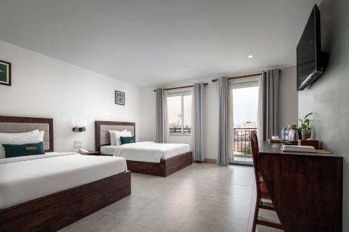 a hotel room with two beds and a television at Vrest Hotel in Phnom Penh