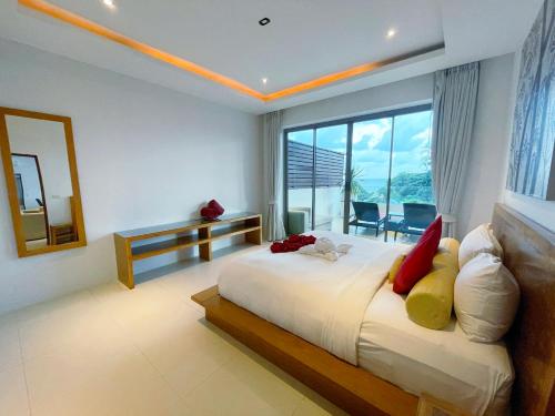 a bedroom with a large bed and a large window at Beach Republic Koh Samui in Lamai