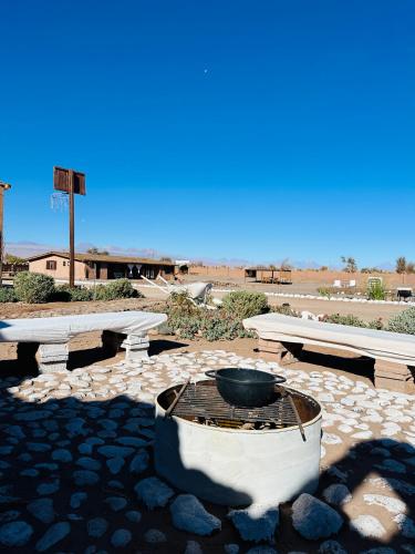 a group of picnic tables and a fire pit in the desert at MAKTVB - EcoLodge San Pedro de Atacama in San Pedro de Atacama