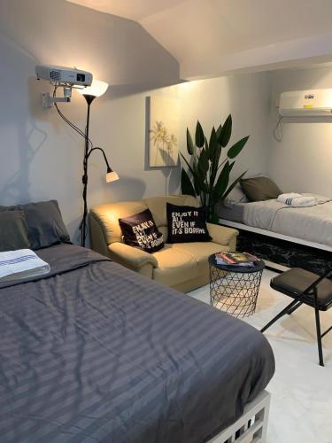 a bedroom with a bed and a living room with a couch at Gray Room The White Haven In Clark in Angeles
