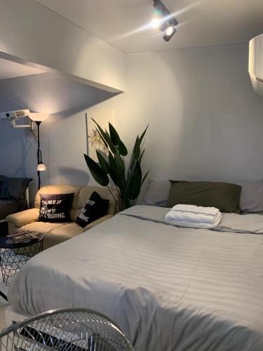 a bedroom with a large bed and a couch at Gray Room The White Haven In Clark in Angeles