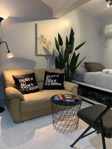 a living room with a couch and a bed at Gray Room The White Haven In Clark in Angeles