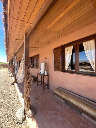 a patio with a hammock and a table and windows at MAKTVB - EcoLodge San Pedro de Atacama in San Pedro de Atacama