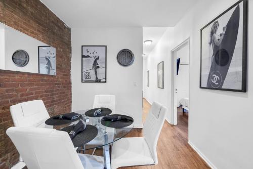 a dining room with a glass table and white chairs at Chic 3Bd In Prime Park Slope in Brooklyn