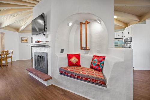 a living room with a fireplace and red pillows at Taos Pine Home in Taos