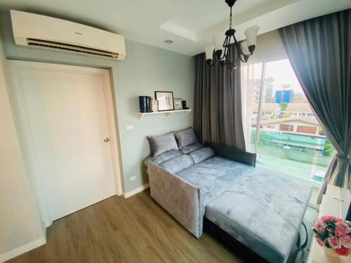 a living room with a couch and a window at Oasis at The BluX, Bangsaen beach in Ban Bang Saen (1)