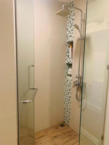 a shower stall with a glass door and a shower at Oasis at The BluX, Bangsaen beach in Ban Bang Saen (1)