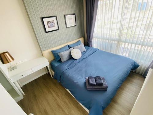 a bedroom with a blue bed with two towels on it at Oasis at The BluX, Bangsaen beach in Ban Bang Saen (1)