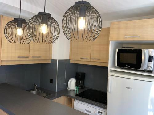 - une cuisine avec deux lampes suspendues et un four micro-ondes dans l'établissement Appartement cosy à Plagne 1800, 4-5 pers, accès piscine - FR-1-181-2842, à La Plagne Tarentaise