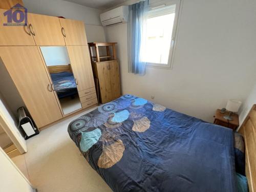 - une chambre avec une couette bleue sur un lit dans l'établissement Pavillon à 50m de la plage avec parking et climatisation pour 4 personnes - FR-1-781-62, à Valras-Plage