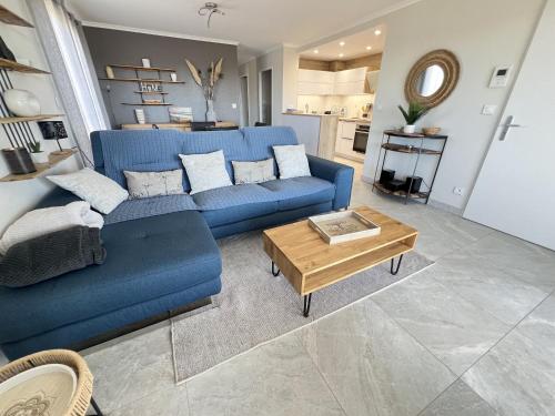 un salon avec un canapé bleu et une table dans l'établissement Appartement moderne climatisé, terrasse sud, 4 pers, parking - FR-1-781-63, à Valras-Plage