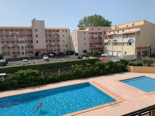 2 piscines sur un balcon d'un bâtiment dans l'établissement Charmant T2 climatisé avec piscine et parking à 100m de la mer - FR-1-607-207, au Cap d'Agde