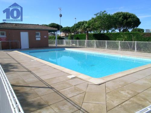 une piscine avec de l'eau bleue dans une cour dans l'établissement Pavillon avec piscine, à 350m de la plage, 6 pers, parking privé - FR-1-781-61, à Vendres