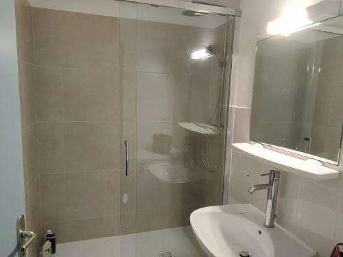 une salle de bain avec une douche, un lavabo et un miroir dans l'établissement Pavillon avec piscine, à 350m de la plage, 6 pers, parking privé - FR-1-781-61, à Vendres