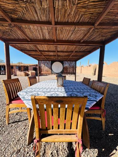 a table and chairs under a wooden roof at MAKTVB - EcoLodge San Pedro de Atacama in San Pedro de Atacama