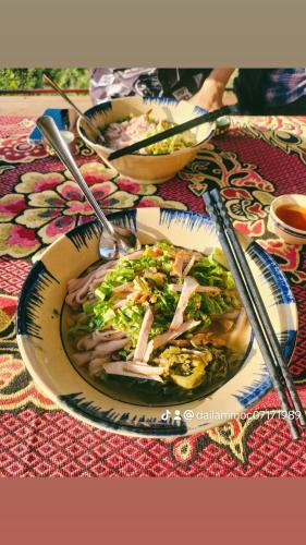 a table with two plates of food on a table at Moc's House bắc hà in Bắc Hà