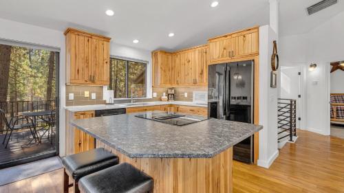 a kitchen with wooden cabinets and a black refrigerator at Diamond Peak - Unit 20 in Sunriver