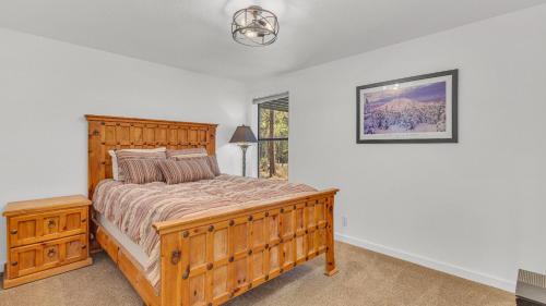 a bedroom with a large wooden bed and a window at Diamond Peak - Unit 20 in Sunriver