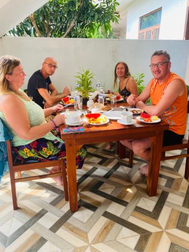 a group of people sitting around a table eating food at Mario Family Villa and Restaurant in Negombo