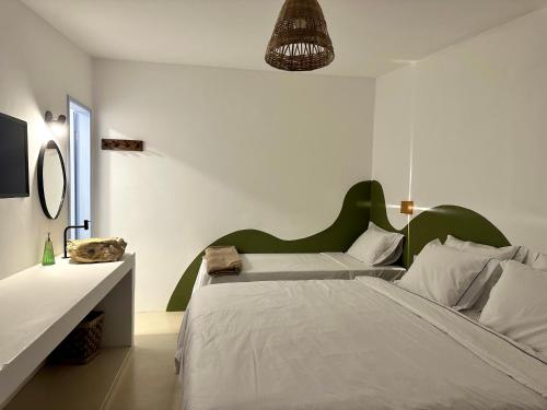 a bedroom with two beds and a green headboard at Pousada Vilab in Arraial d'Ajuda