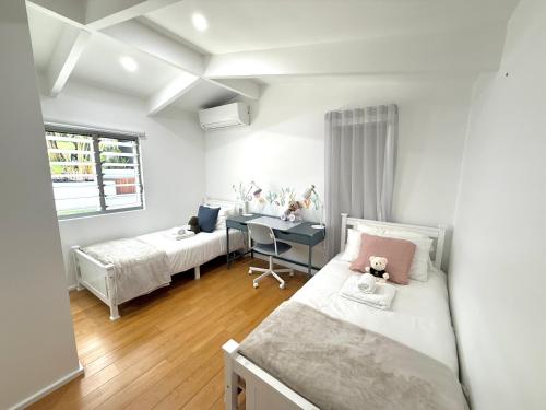 a bedroom with two beds and a desk in it at Oceanview 3-Bedroom Villa with Garden, Deck, Full Kitchen & WiFi in Halletts Cove