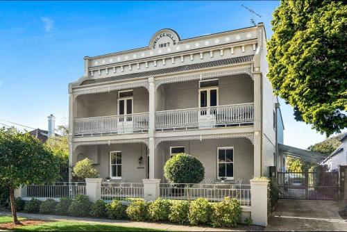 a large white building with a balcony on a street at Little Terrace Bowral 1 in Bowral