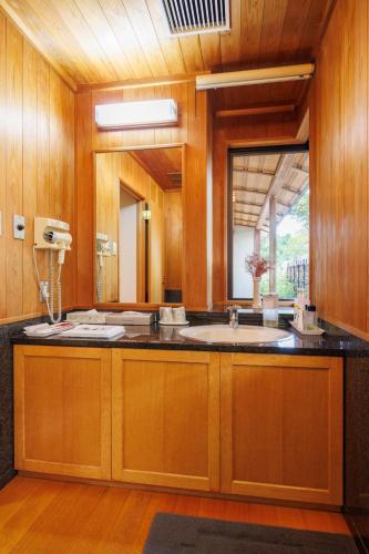 a bathroom with a sink and a large mirror at 四季亭 Shikitei in Nara