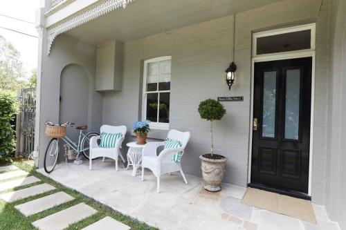 a porch with a table and chairs and a door at Little Terrace Bowral 1 in Bowral