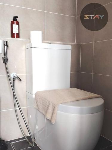 a bathroom with a toilet with a towel on it at DP Warm Sunshine Family Netflix Legoland By STAY in Iskandar Puteri