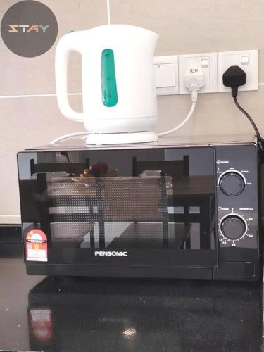a microwave with a white jug on top of it at DP Warm Sunshine Family Netflix Legoland By STAY in Iskandar Puteri
