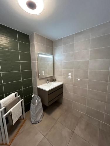 a bathroom with a sink and a mirror at Cosy Sand plages et nature in Étang-Salé