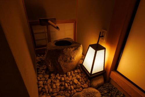 a room with a rock and a lamp and a lantern at 四季亭 Shikitei in Nara