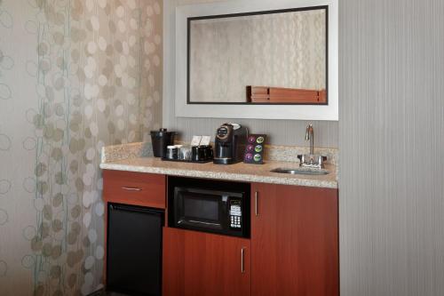 a kitchen with a sink and a microwave at Courtyard by Marriott Ottawa East in Ottawa