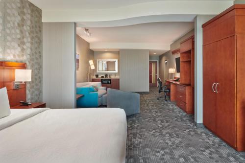 a hotel room with a bed and a living room at Courtyard by Marriott Ottawa East in Ottawa