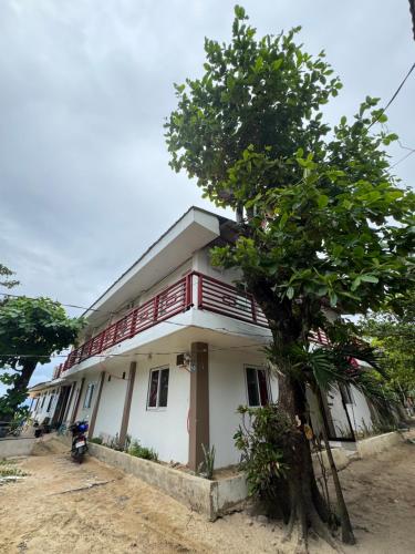 a house with a tree in front of it at Dandal Bay View Inn in Nacpan