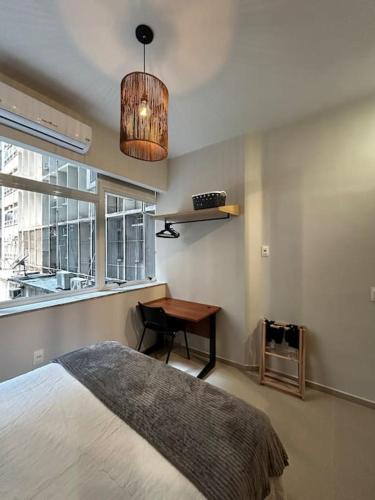 une chambre avec un lit, un bureau et une fenêtre dans l'établissement Moderno Loft - Centro Rio de Janeiro, à Rio de Janeiro