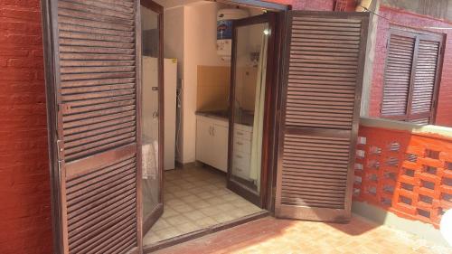 a room with a kitchen with wooden doors in it at Departamento frente al mar y con vistas a la playa in Villa Gesell