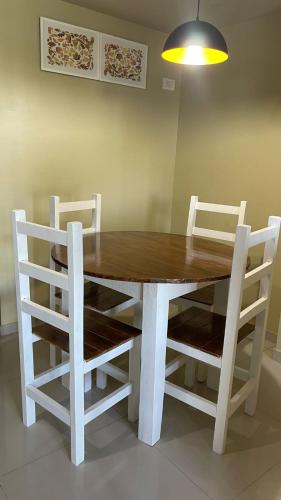 a dining room table with white chairs around it at Alquiler Temporario Tucumán Con Cochera Y Pileta in San Miguel de Tucumán