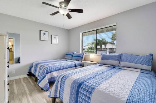 ein Schlafzimmer mit zwei Betten und einem Deckenventilator in der Unterkunft Private Cottage in West Palm Beach Florida in Palm Beach Gardens