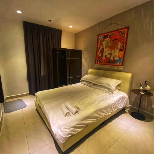 a bed in a bedroom with a painting on the wall at Ipoh Apartment Suites in Ipoh