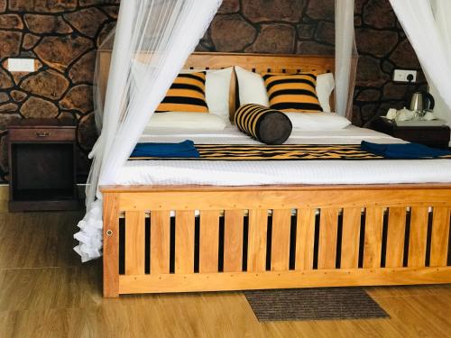 ein Schlafzimmer mit einem Holzbett mit Baldachin in der Unterkunft Angel's View Cottage Ella in Ella