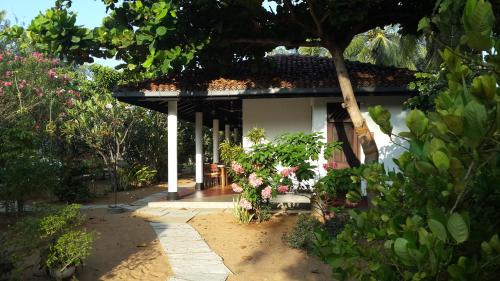 a house with a bunch of flowers in front of it at The Danish Villa Resort in Arugam Bay
