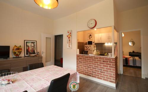 une cuisine et une salle à manger avec une table et une horloge murale dans l'établissement Bourrin le rocher, à Saint-Martin-dʼUriage