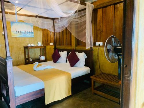 ゴールにあるSuha Beach Double Cabanaのベッドルーム1室(ベッド2台、ファン付)